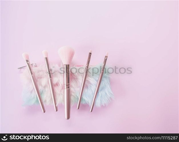 Beauty and Makeup concept from facial cosmetics, blush brush, brow brush, highlighter palette and eyeshadows with pink-tone for face make up on pink background.