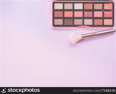 Beauty and Makeup concept from facial cosmetics, blush brush, highlighter palette and eye shadows with pink-tone for face make up on pink background.