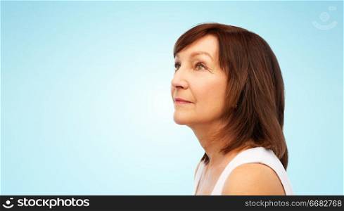 beauty and old people concept - portrait of senior woman over blue background. portrait of senior woman over blue background