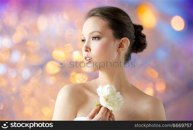 beauty and people concept - beautiful asian woman or bride with peony flower over holidays lights background. beautiful asian woman with flower. beautiful asian woman with flower