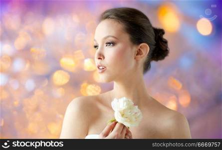 beauty and people concept - beautiful asian woman or bride with peony flower over holidays lights background. beautiful asian woman with flower. beautiful asian woman with flower