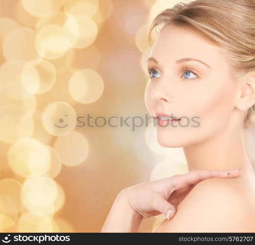 beauty and people concept - face of beautiful young woman over beige lights background