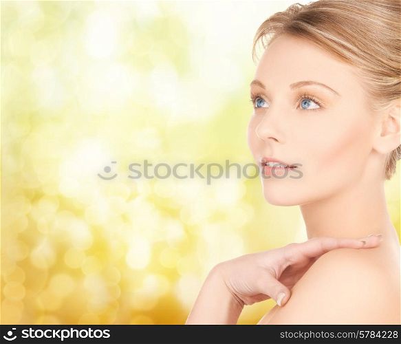 beauty and people concept - face of beautiful young woman over yellow lights background