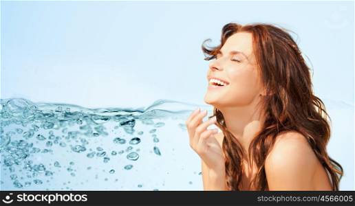 beauty and people concept - happy beautiful woman over water splash on blue background. happy beautiful woman over lights background