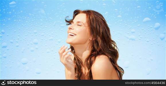 beauty and people concept - happy beautiful woman over wet blue background. happy beautiful woman over wet blue background