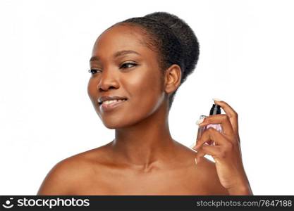 beauty and people concept - portrait of happy smiling young african american woman with bare shoulders with perfume over white background. young african american woman with perfume