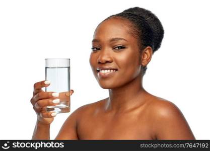beauty and people concept - portrait of happy smiling young african american woman with bare shoulders with glass of water over white background. young african american woman with glass of water