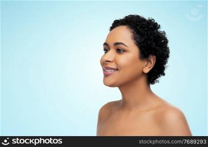 beauty and people concept - portrait of happy smiling young african american woman with bare shoulders over blue background. portrait of young african american woman