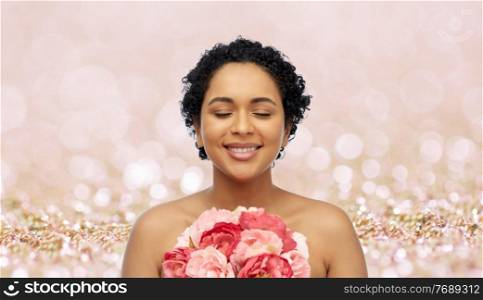 beauty and people concept - portrait of happy smiling young african american woman with flowers over pink glitter background. portrait of african american woman with flowers