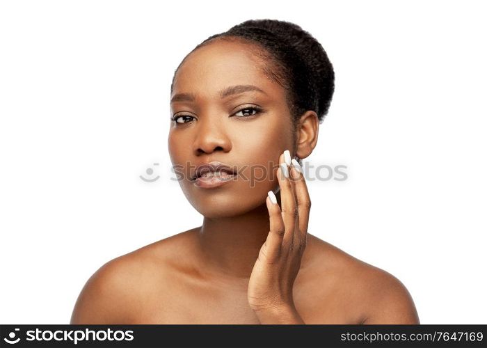 beauty and people concept - portrait of young african american woman with bare shoulders touching her face over white background. portrait of african woman touching her face