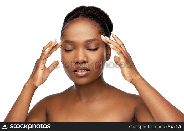 beauty and people concept - portrait of young african american woman with bare shoulders doing face massage over white background. portrait of african woman doing face massage