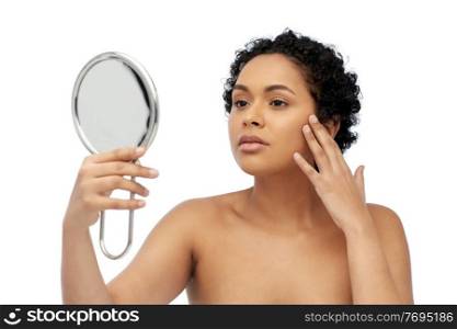 beauty and people concept - portrait of young african american woman with bare shoulders looking to mirror over white background. african american woman looking to mirror
