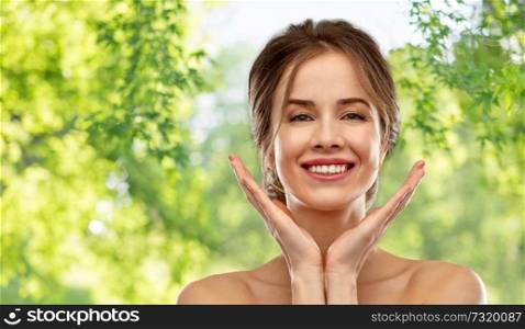 beauty and people concept - smiling young woman with bare shoulders over green natural background. smiling young woman over grey background