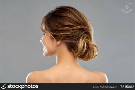 beauty and people concept - young woman with bare shoulders from back over grey background. young woman from back over grey background