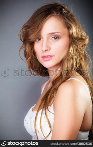 Beauty and sensuality of women. Young attractive long haired girl wearing lingerie on gray background.