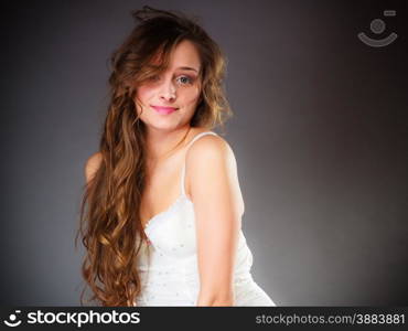 Beauty and sensuality of women. Young attractive long haired girl wearing lingerie on gray background.