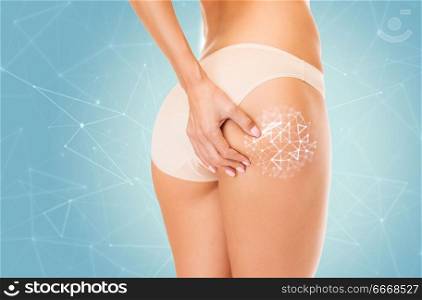 beauty and slimming concept - close up of woman body in cotton underwear over low poly shape projection on blue background. close up of woman touching her buttocks. close up of woman touching her buttocks