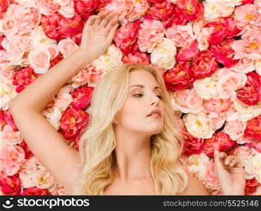 beauty and spa concept - beautiful woman and background full of roses