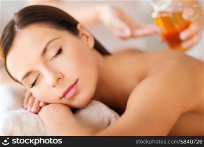 beauty and spa concept - beautiful woman in spa salon getting oil treatment. beautiful woman in spa salon