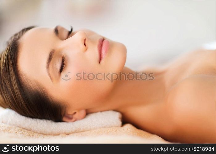 beauty and spa concept - beautiful woman in spa salon lying on the massage desk. beautiful woman in spa salon