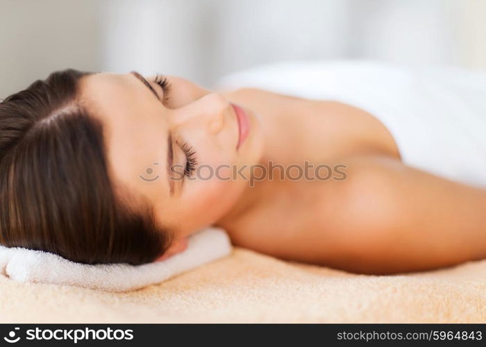 beauty and spa concept - beautiful woman in spa salon lying on the massage desk. beautiful woman in spa salon