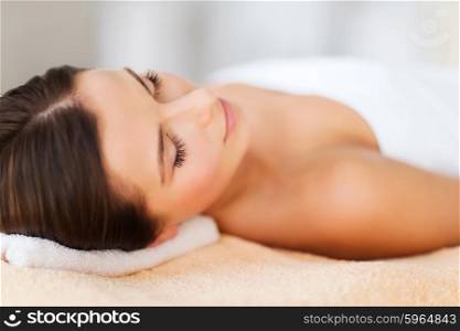 beauty and spa concept - beautiful woman in spa salon lying on the massage desk. beautiful woman in spa salon