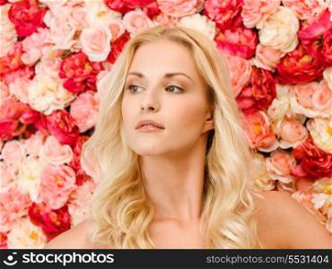 beauty and spa concept - face of beautiful woman and background full of roses