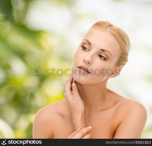 beauty and spa concept - face of beautiful woman touching her face skin