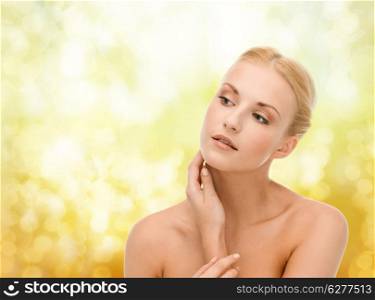 beauty and spa concept - face of beautiful woman touching her face skin