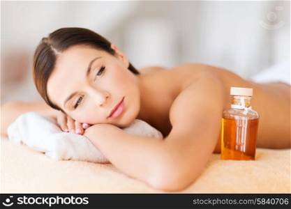 beauty and spa concept - happy woman in spa salon lying on the massage desk. happy woman in spa salon