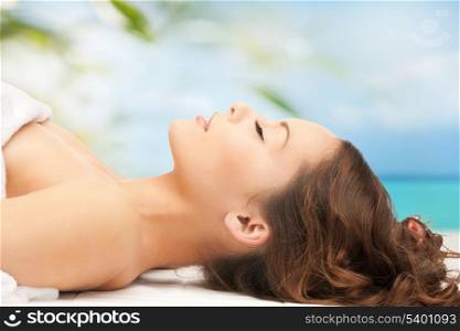 beauty and spa concept - woman in spa lying on the massage desk