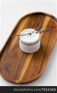 beauty and wellness concept - close up of lavender moisturizer on wooden tray. close up of lavender moisturizer on wooden tray