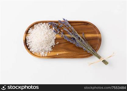 beauty and wellness concept - sea salt heap and lavender on wooden tray. sea salt heap and lavender on wooden tray