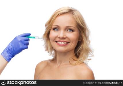 beauty, anti-aging cosmetic surgery concept - smiling woman face and beautician hand in glove with syringe making injection to cheek