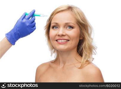 beauty, anti-aging cosmetic surgery concept - smiling woman face and beautician hand in glove with syringe making injection to forehead