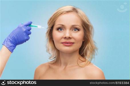 beauty, anti-aging cosmetic surgery concept - smiling woman face and beautician hand in glove with syringe making injection to eye contour area over blue background