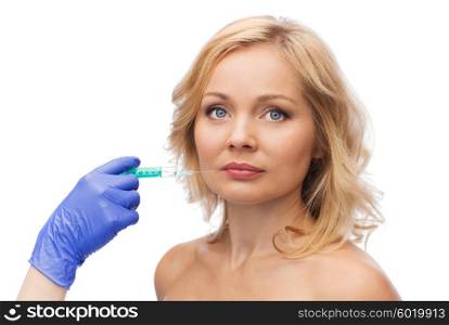 beauty, anti-aging cosmetic surgery concept - woman face and beautician hand in glove with syringe making injection to lips