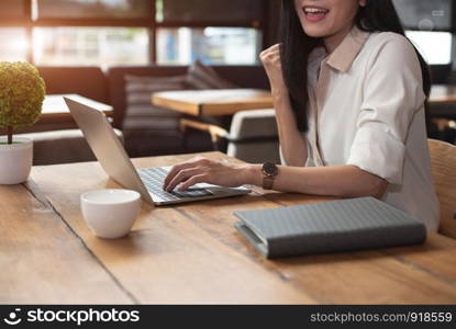 Beauty Asian woman having cheerful gesture after finishing job happily with laptop computer in cafe. People and lifestyles concept. Technology and Business working theme. Occupation and job theme.