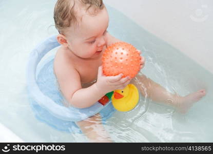 beauty baby boy in bath with rubber ball