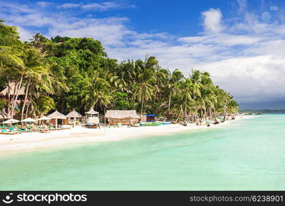 Beauty beach with coconut palms on the blue sky background