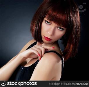 Beauty. Beautiful red hair woman over dark background