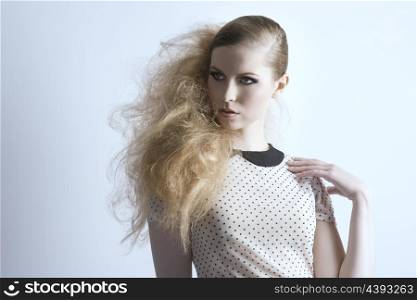 beauty blonde woman with dark make-up and creative punk hair-style posing in fashion portrait