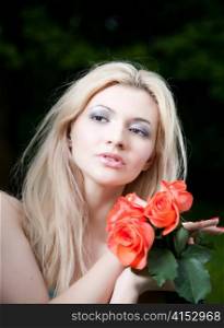 Beauty Blonde Woman With Roses In Hands. Close-Up Portrait