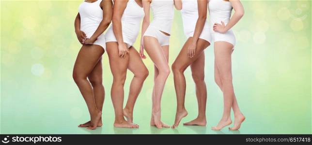 beauty, body positive and people concept - group of diverse women in white underwear over summer green lights background. group of happy diverse women in white underwear. group of happy diverse women in white underwear