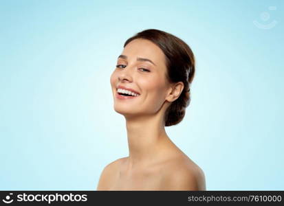 beauty, bodycare and people concept - beautiful young woman with bare shoulder over blue background. beautiful young woman with bare shoulder