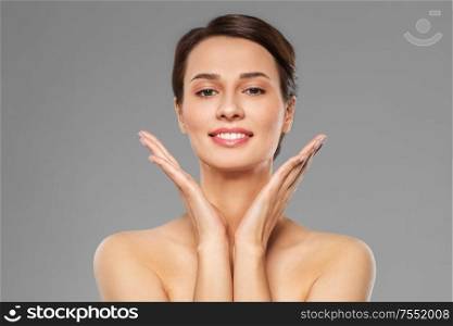 beauty, bodycare and people concept - beautiful young woman with bare shoulder over grey background. beautiful young woman with bare shoulder