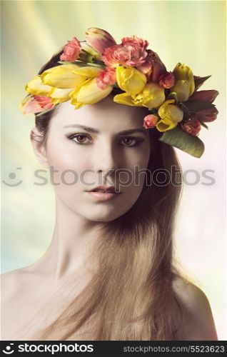 beauty close-up portrait of cute young lady with spring floral style. Looking in camera with colorful make-up and wearing floral spring garland on her head