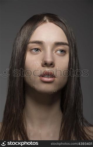 beauty close-up portrait of pretty brunette woman with long wet smooth hair and some water drops on the visage