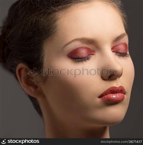 beauty close-up portrait of pretty young woman with brown hair and glossy red make-up and closed eyes