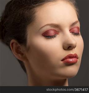 beauty close-up portrait of pretty young woman with brown hair and glossy red make-up and closed eyes